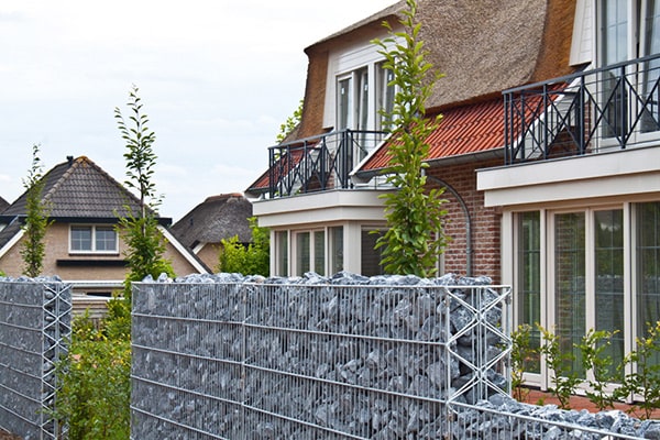 gabionensteine-preise-garten-zaun-mit-gabionen-und-Haus-min